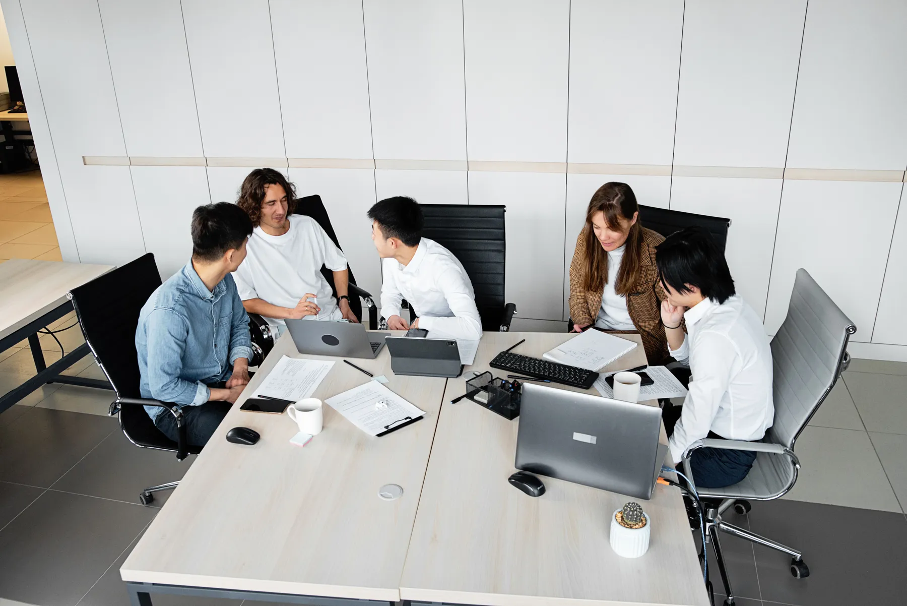 Equipo de trabajo reunido alrededor de una mesa de oficina